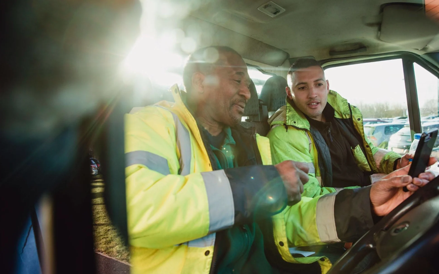 Two driver sin a cab with a phone
