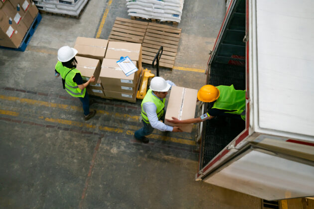 American warehouse workers loading a truck with boxes - freight transportation concepts
