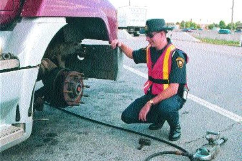 CLOSE LOOK: Chris Davies, an inspector with the Ontario Ministry of Transportation, inspects a truck's brake system. Photo by Katy de Vries