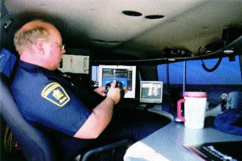 HEAT SEEKER: Inspection officer Ken Pollard monitors vehicles as they pull into the Balzac inspection station. Photo by James Menzies