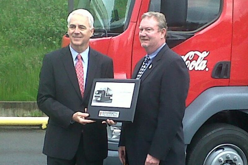 At left, Gary Moore, Kenworth general manager and Paccar vice-president, presents a  plaque and the keys to Kenworth's first K370 cabover to Coca-Cola Refreshments' Bob Slack, vice-president of field operations for the Pacific Northwest Marketing Unit.