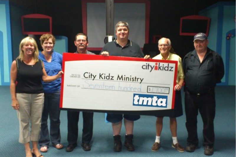 Steve Granville, Fred Pedler, Bob Dawson and Paul Crossman present a big $,1700 cheque to the funding team from City Kidz.