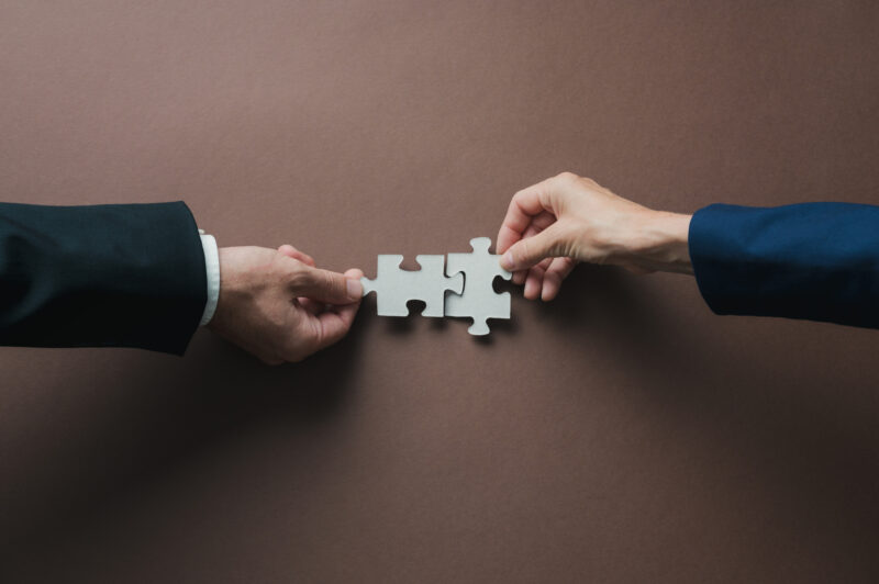 Pictures of hands fitting puzzle pieces