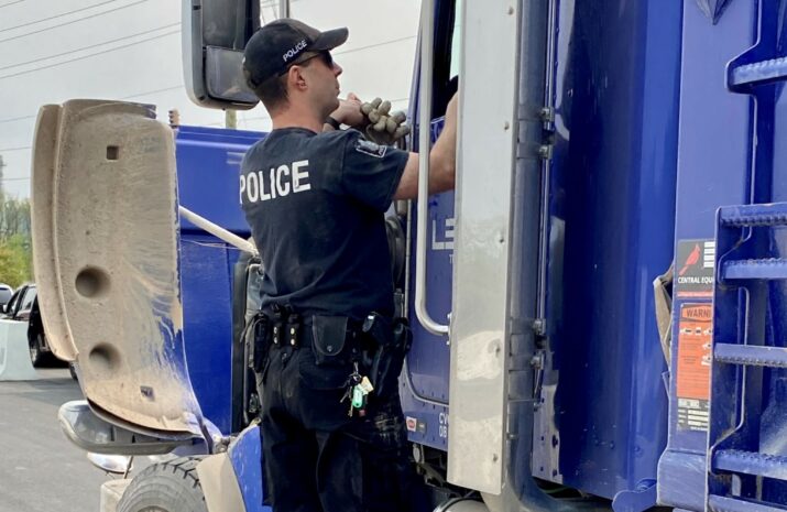 Police officer on the step of a truck