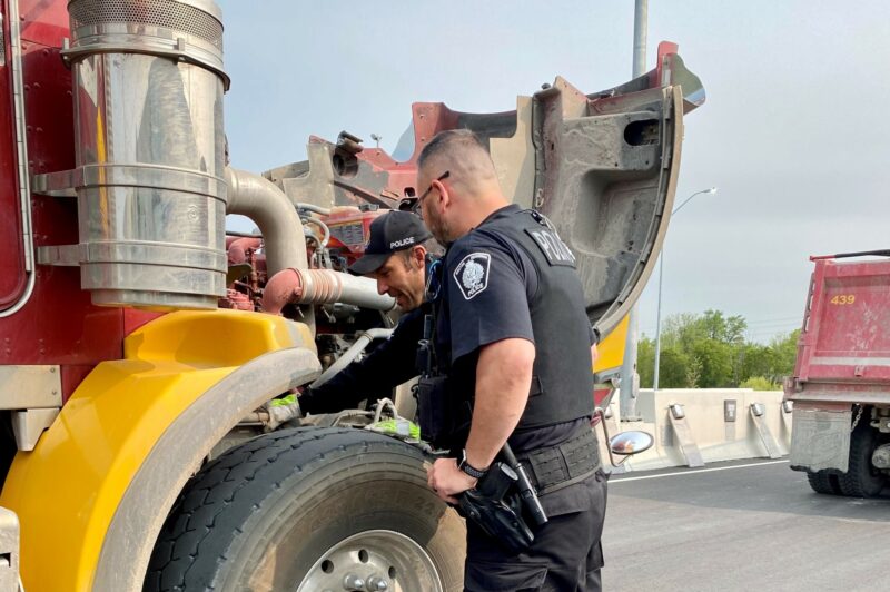 Police officers inspect a truck