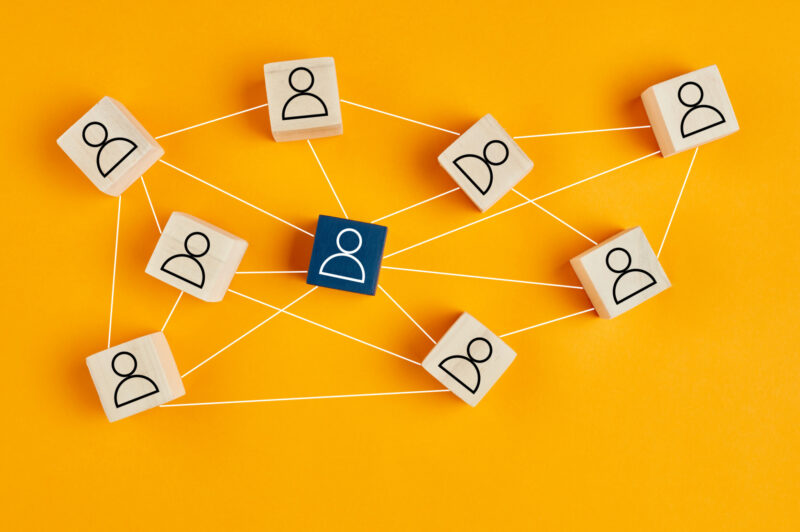Wooden blocks with people icon on yellow background.