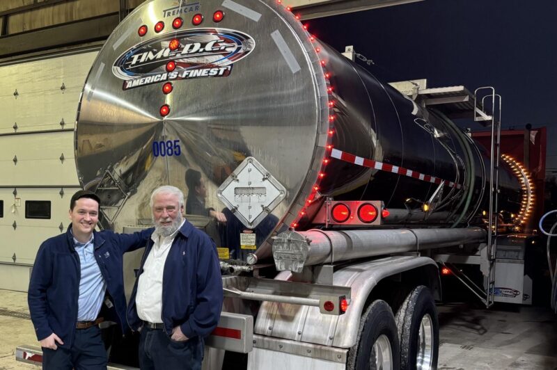 Two men standing behind a trailer