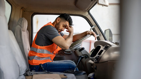 Picture of a sad truck driver with a headache