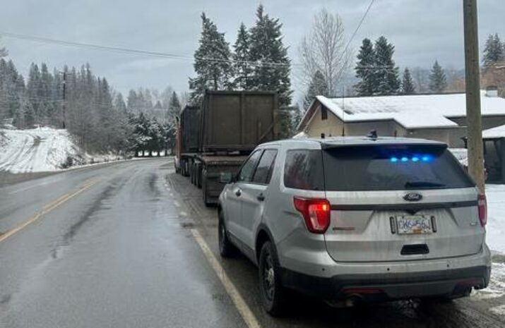 Picture of a police vehicle behind a tractor trailer