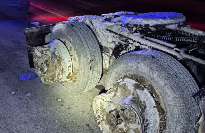 A truck with two tires missing and wheels damaged