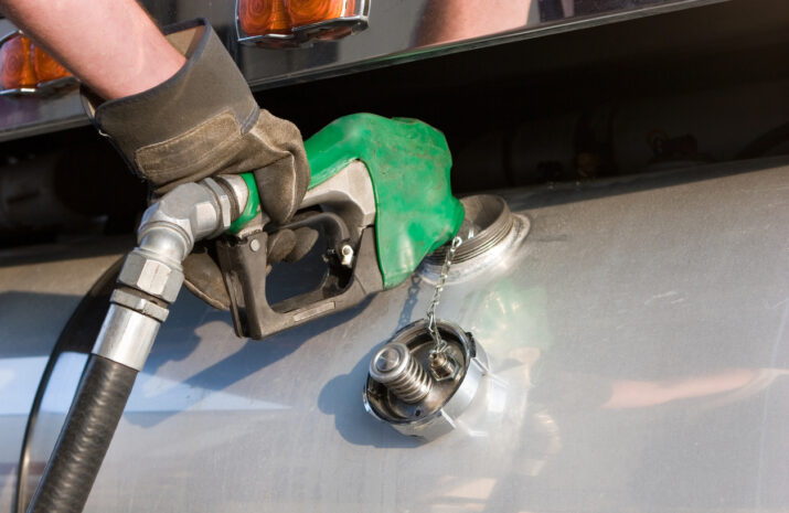 A man fuelling up a freight transport truck
