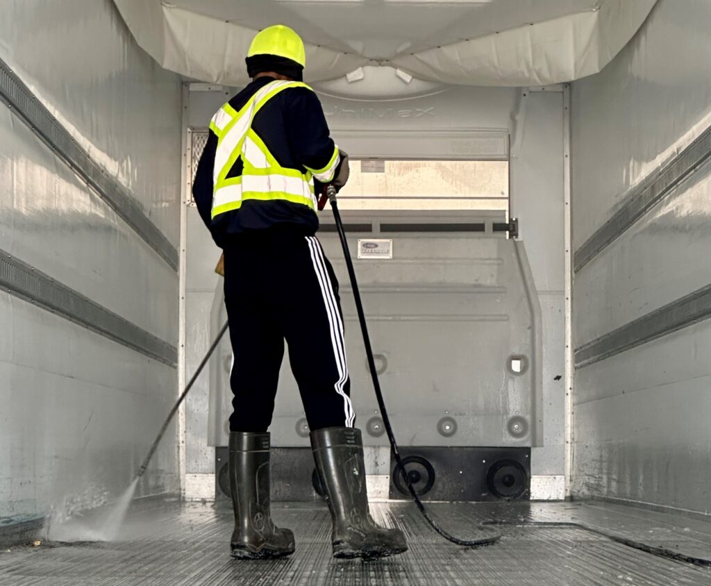 A man washing a the inside of a reefer