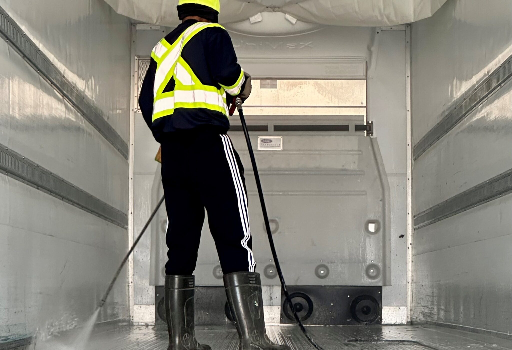 A man washing a the inside of a reefer